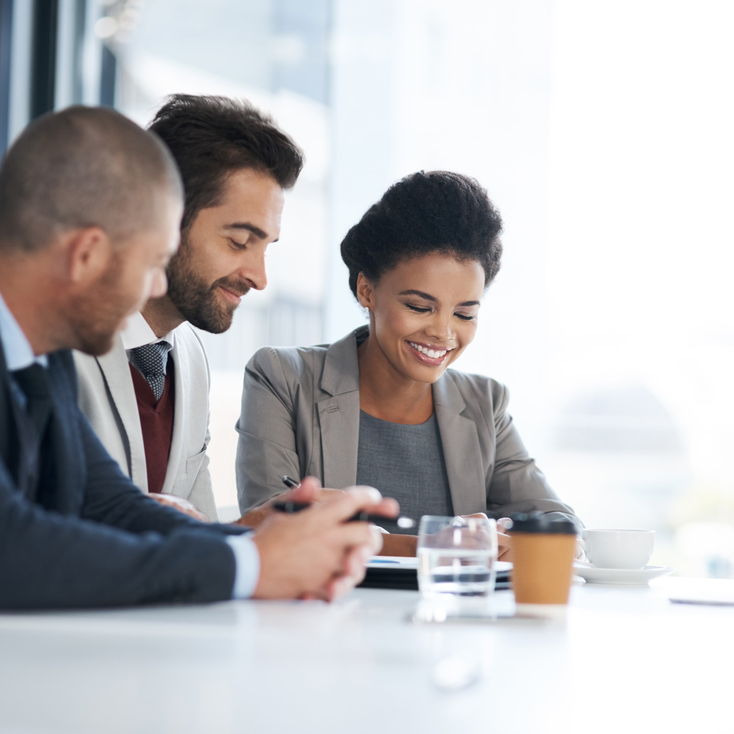 Three People Sitting Discussing By A Window