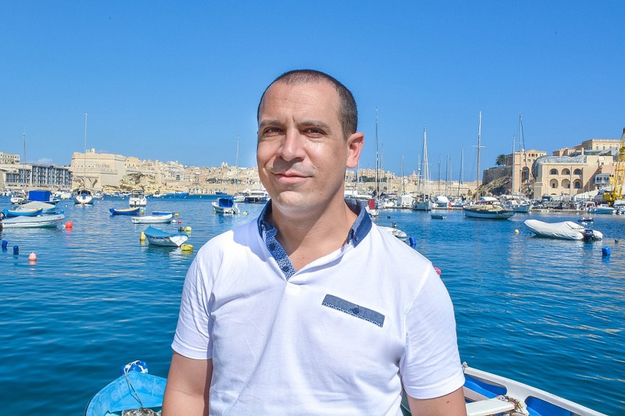 Andrea Garroni smiling for the camera on a boat on water