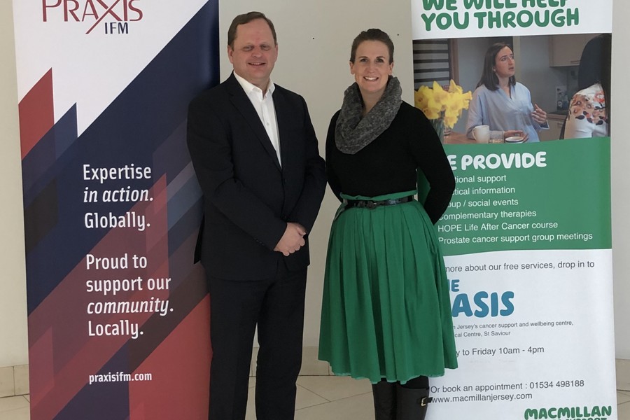 Richard Kearsey standing with a lady in front of Praxis IFM and Macmillan pop up banners