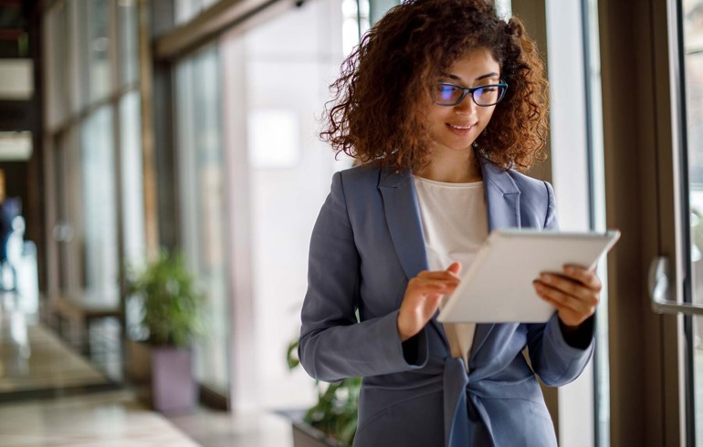 A young woman in a professional environment using her IPad