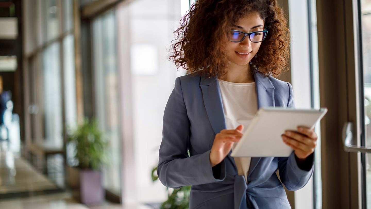 A young woman in a professional environment using her IPad