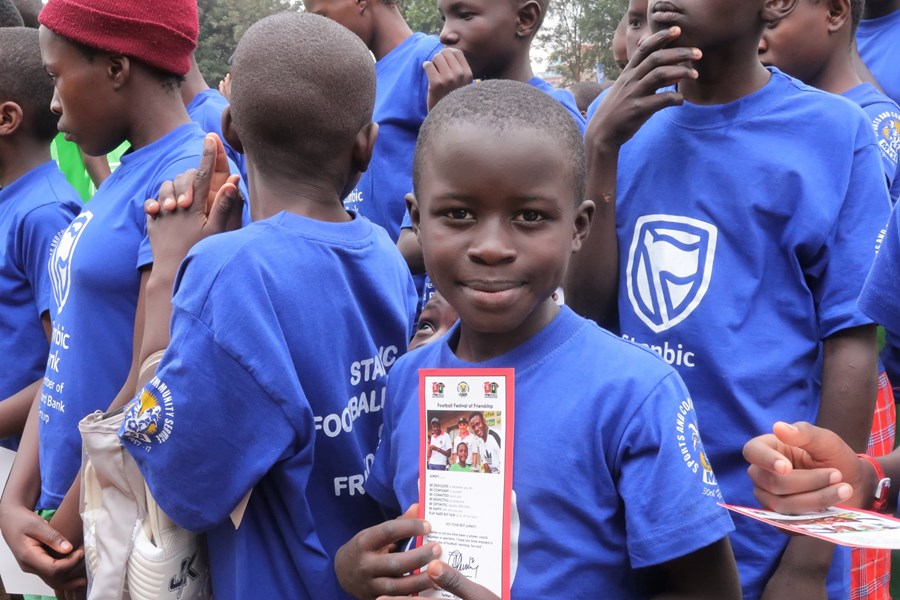 Children in T-shirts holding a leaflet