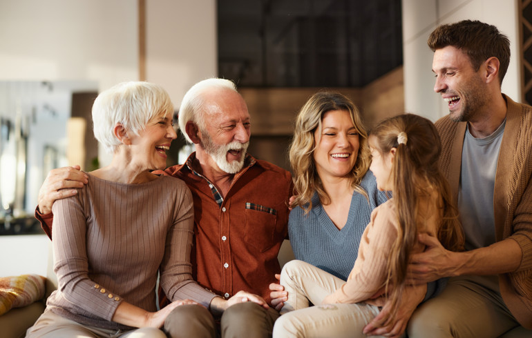 Multigenerational Family Sitting And Smiling