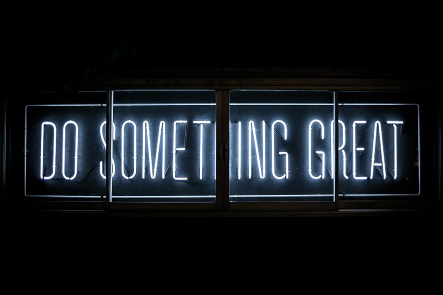 A white neon sign that reads 'DO SOMETHING GREAT'