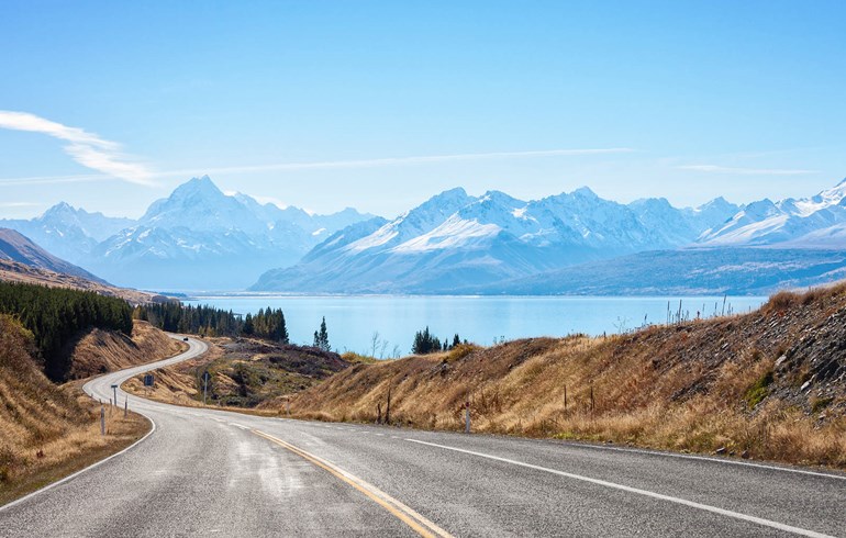 An Image of a Road in New Zealand with Mountains in the Background