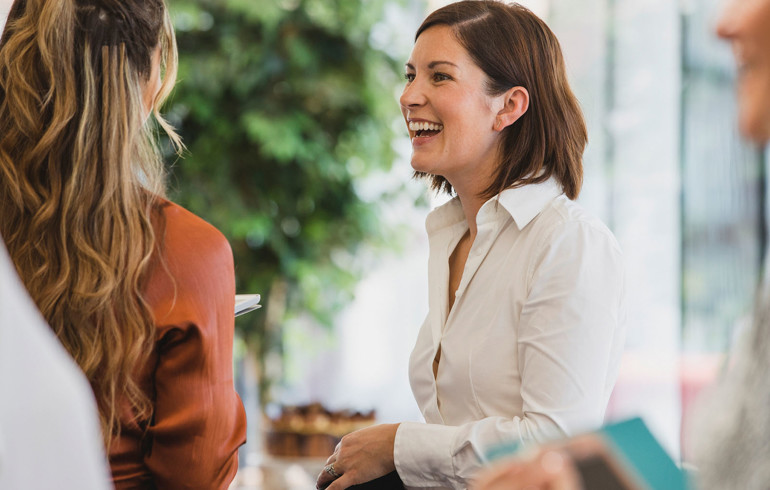 Two women having an enjoyable conversation in a professional setting