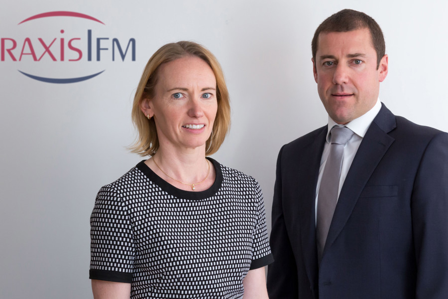 Lorna Morton and Shaun Robert posing in front of the PraxisIFM logo